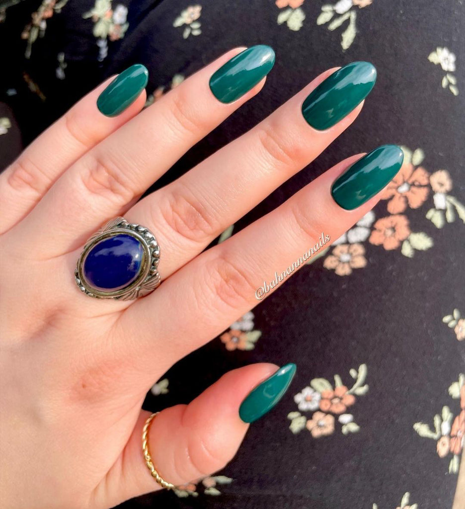 Dark emerald green gel polish on natural nails- oval shape
